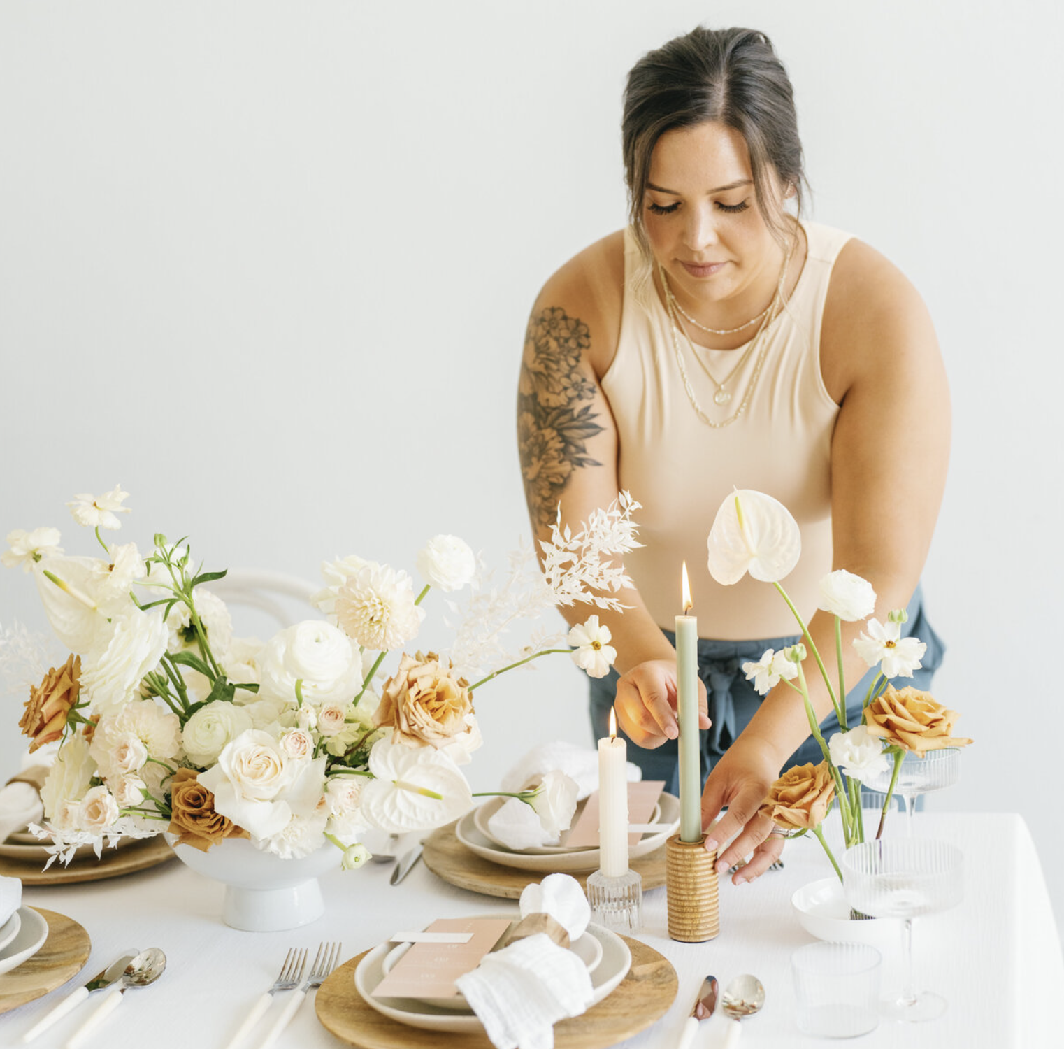 Owner of Eventive Designs setting up a wedding table while thinking through her wedding signage design process.