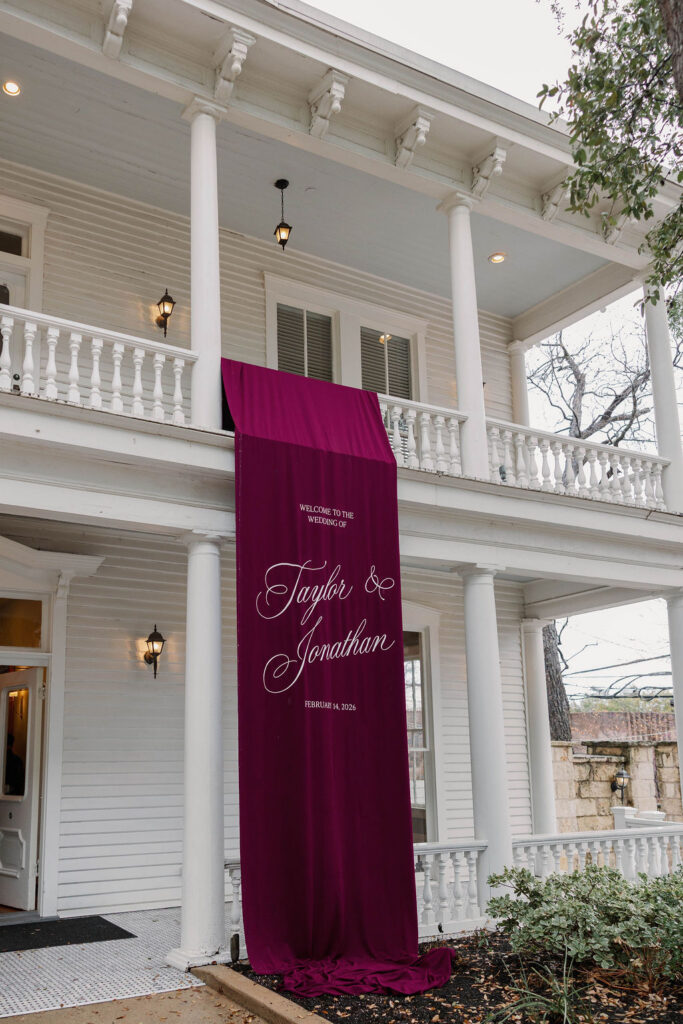 Linen Austin wedding welcome signage draped from balcony